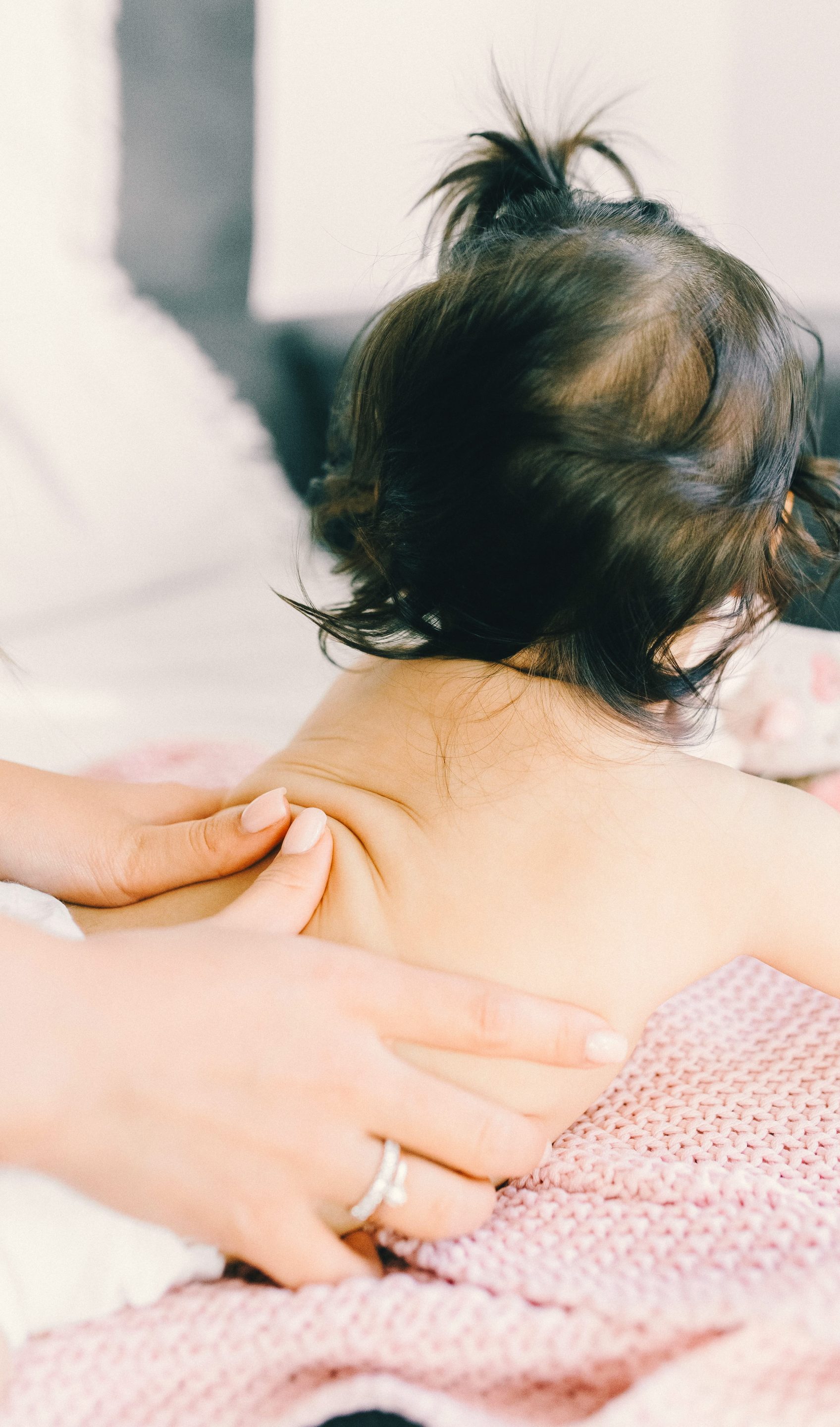 bébé sur le ventre entrain de se faire masser le dos