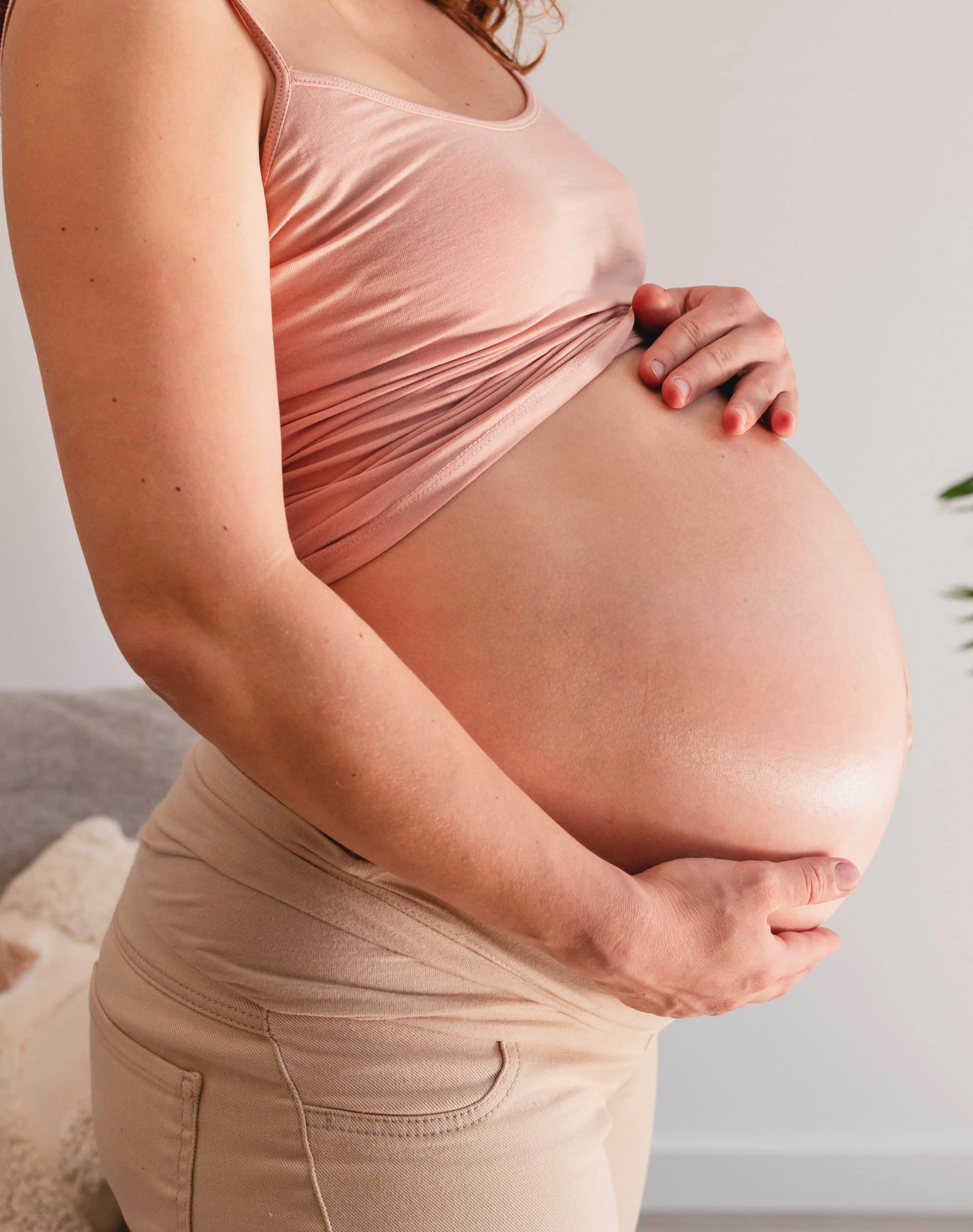 femme enceinte debout se tenant le ventre