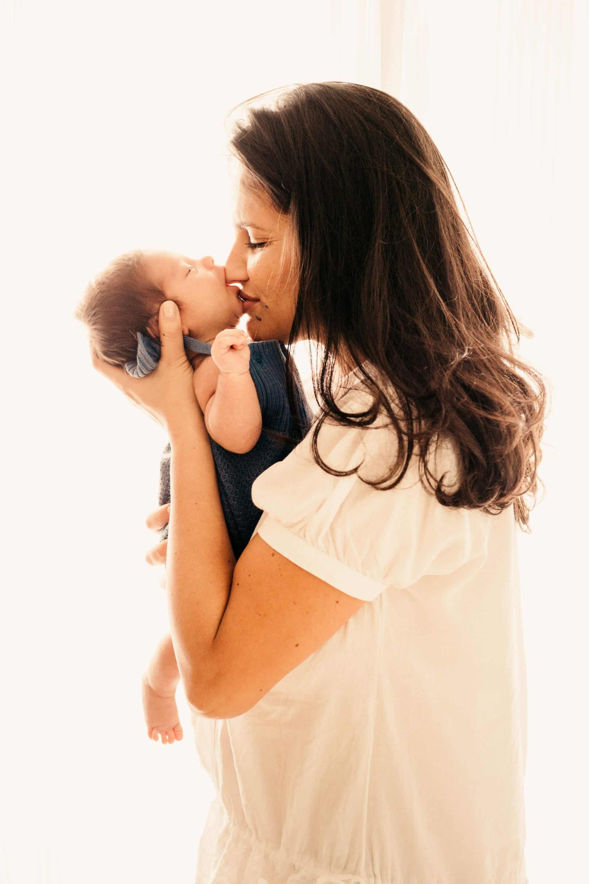maman tenant son bébé dans les bas lui faisant un bisous