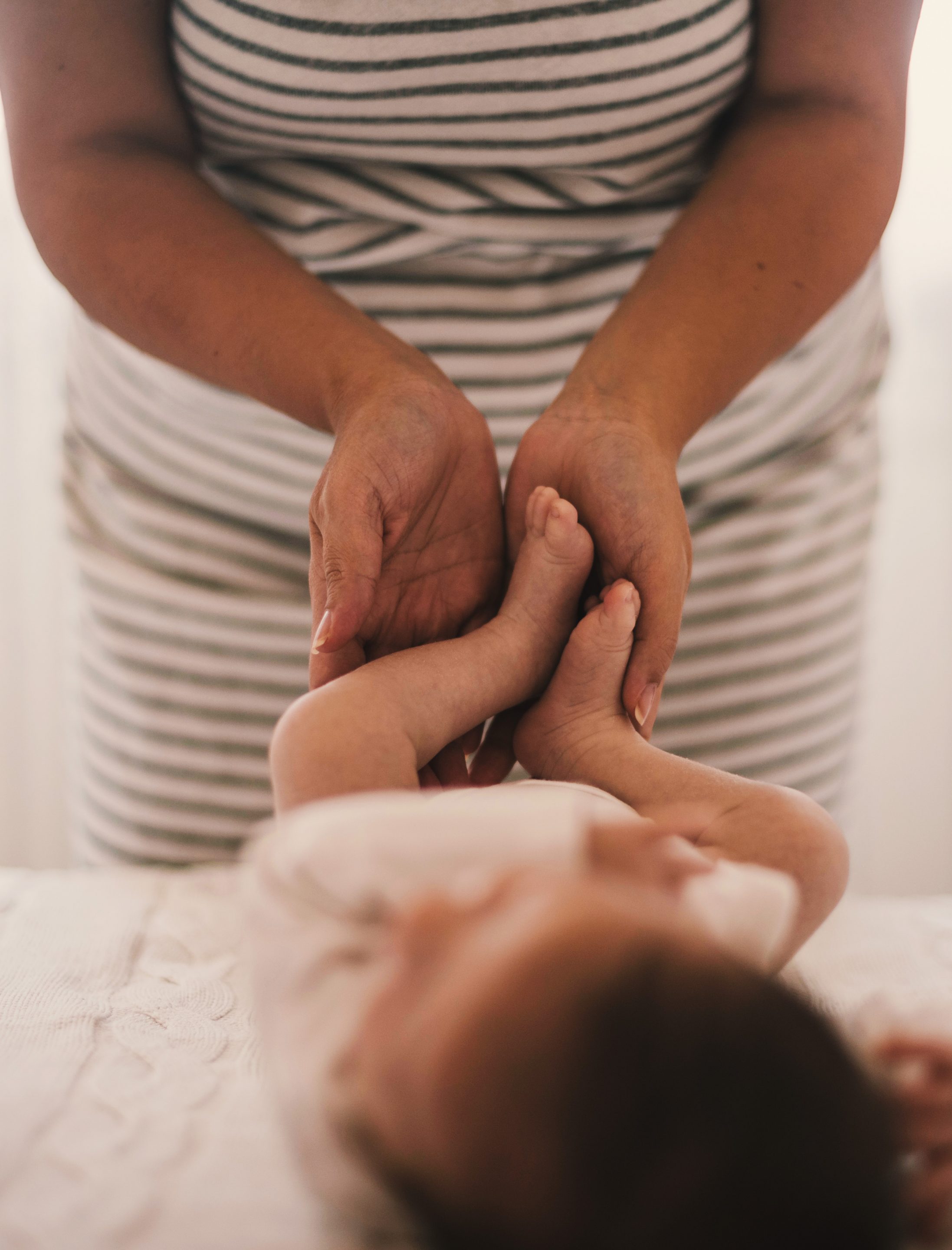 doula entrain de faire de la réflexologie sur les pieds d'un bébé