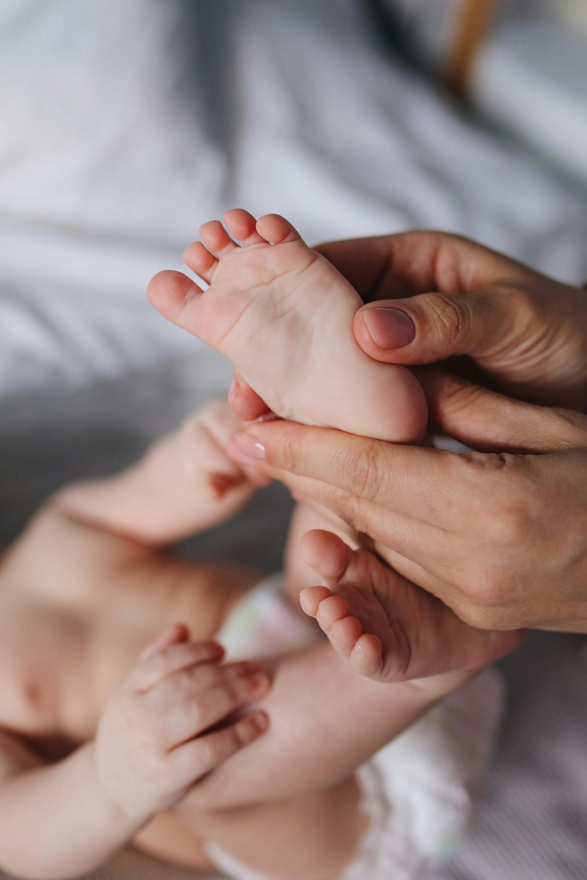 doula entrain de faire la réflexologie sur les pieds d'un bébé
