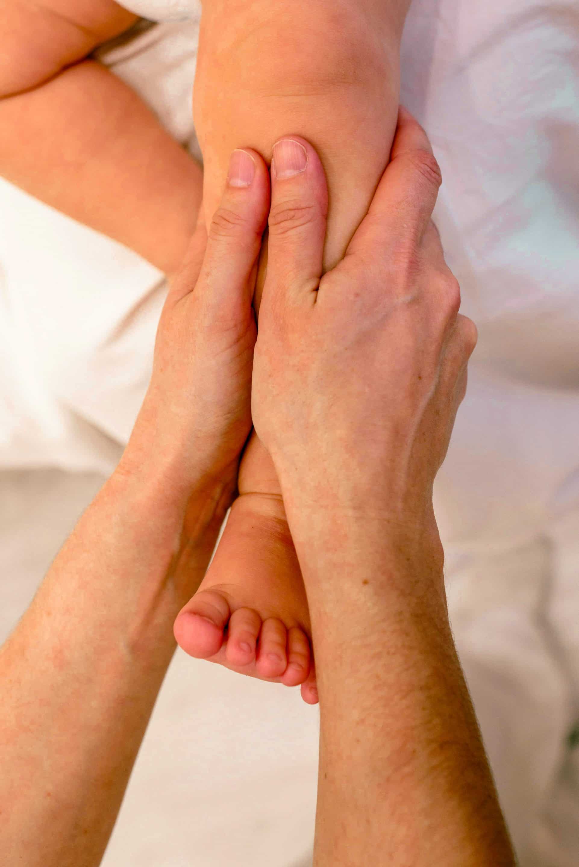 accompagnante périnatale massant la jambre d'un bébé